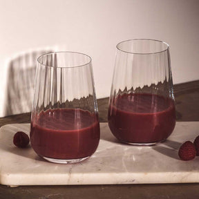 Trinkglas PAOLO mit rotem Saft auf Marmorplatte, daneben Beeren
