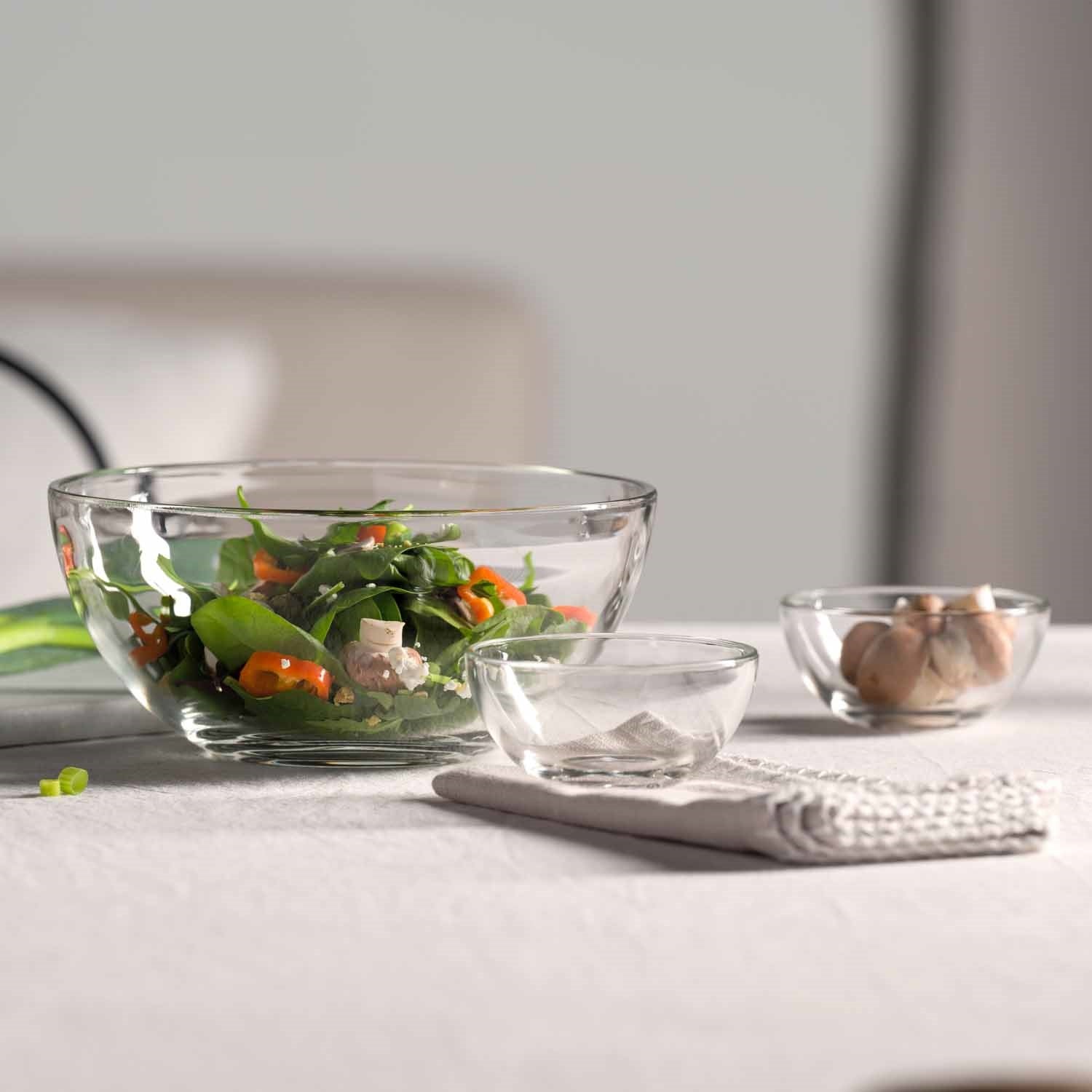 Schale CUCINA mit Salat auf Tisch mit Gläsern und Besteck