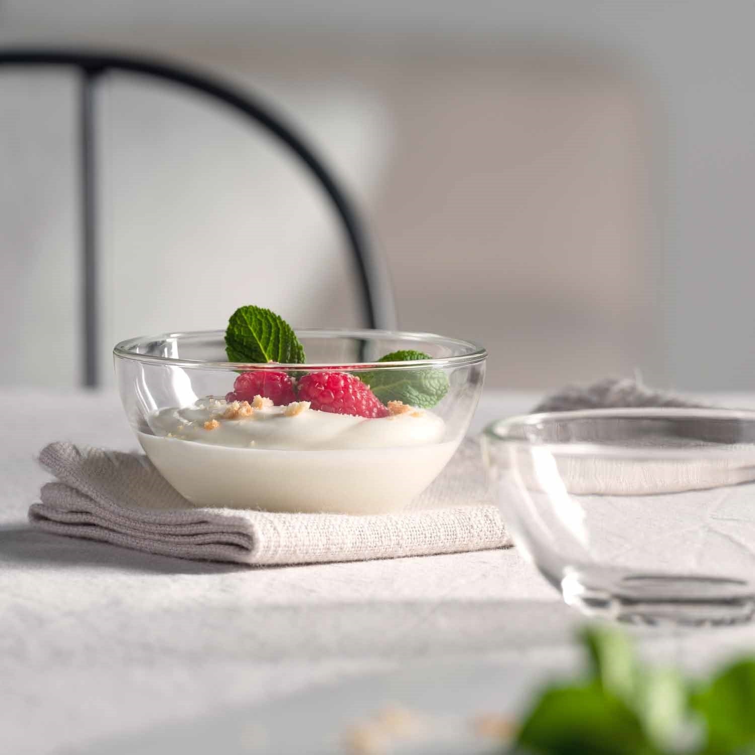 Glasschale CUCINA mit Joghurt, Beeren und Minze auf gedecktem Tisch