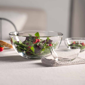 Glasschalen mit Salat und Wasser auf Tisch mit Deko