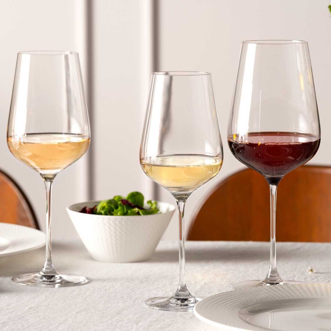 Drei gefüllte Rieslinggläser BRUNELLI auf gedecktem Tisch mit Schale