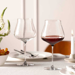 Burgundergläser BRUNELLI auf gedecktem Tisch, eines leer, eines mit Rotwein gefüllt