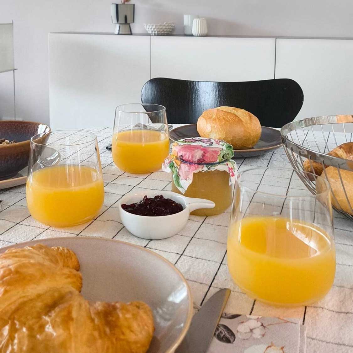 Trinkglas BRUNELLI mit Orangensaft auf gedecktem Frühstückstisch