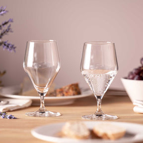 Zwei Wassergläser TWENTY 4 auf gedecktem Tisch mit Blumen und Gebäck