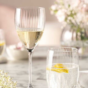 Rieslingglas POESIA mit Weißwein und Mineralwasser auf gedecktem Tisch