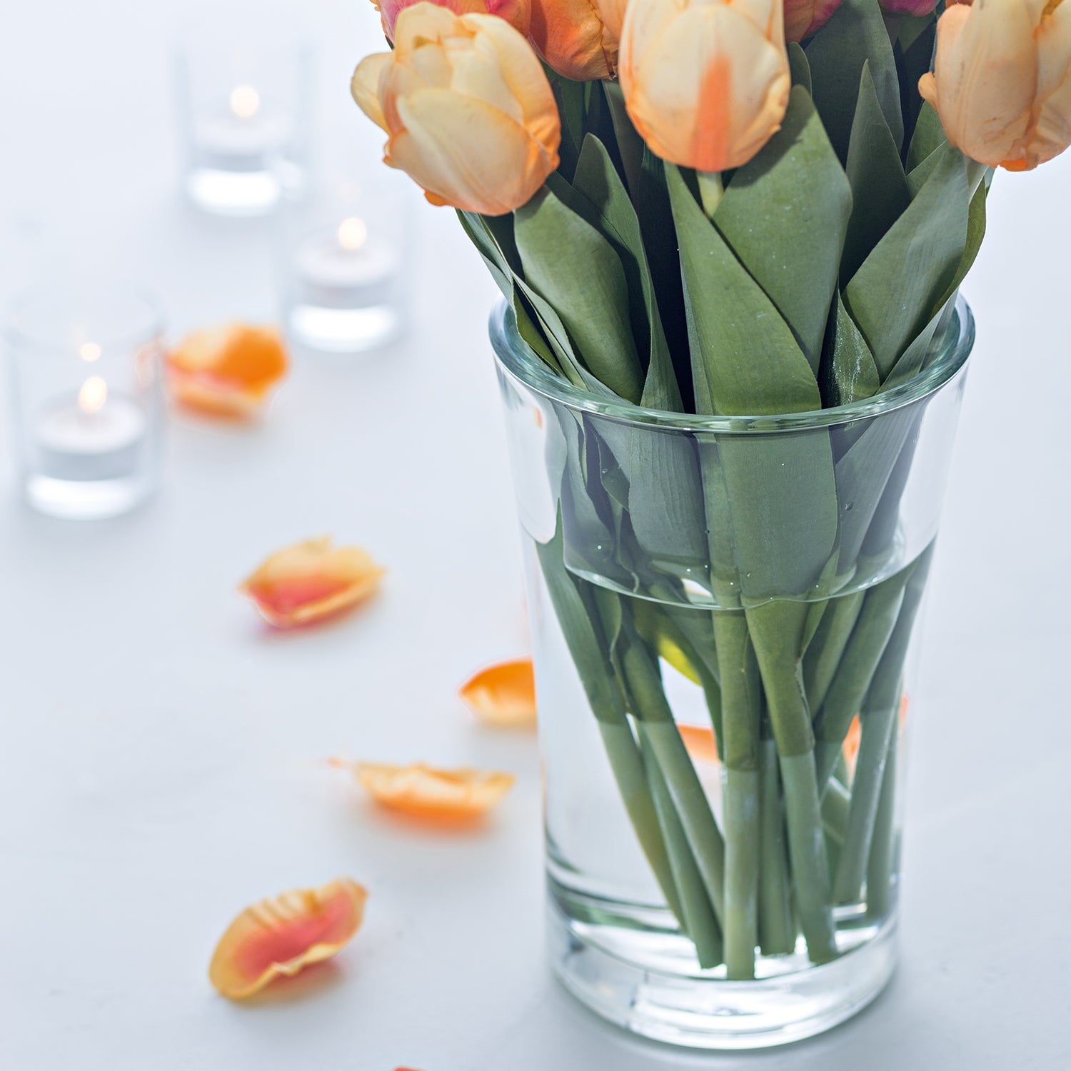Glasvase BLOOM mit Tulpen und Kerzen auf weißem Untergrund