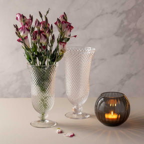Vase auf Fuß POESIA mit rosa Blüten, leere Vase, schwarze Kerze auf Marmor