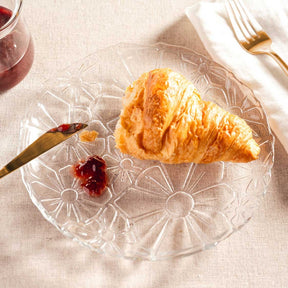Teller GIORNO mit Croissant, Besteck und Rotwein auf gedecktem Tisch