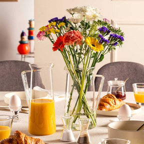 Krug GIORNO mit Blumenstrauß auf gedecktem Frühstückstisch
