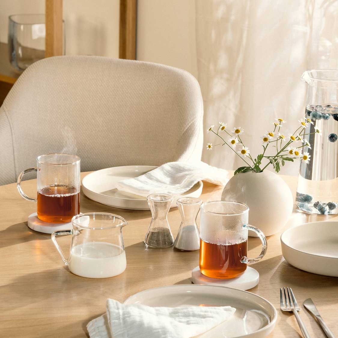 Kännchen GIORNO auf gedecktem Tisch mit Getränken und Blumenvase