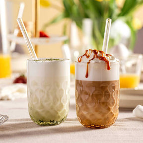 Zwei Matcha Latte Gläser GOCCE mit Glastrinkhalmen auf gedecktem Tisch