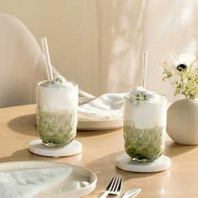 Matcha Latte Gläser GOCCE mit Glastrinkhalm auf gedecktem Tisch