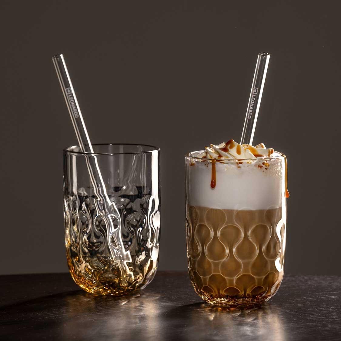 Zwei Caramel Macchiato Gläser GOCCE mit Glastrinkhalmen, links leer, rechts mit Getränk und Karamellsoße