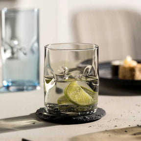 Trinkglas VESUVIO mit Limettenscheiben und Eis auf schwarzem Untersetzer