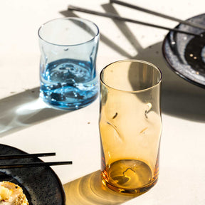 Trinkgläser VESUVIO amber mit Wasser und Saft auf Tisch mit Schatten