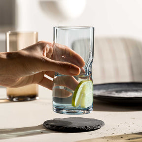 Hand hält Trinkglas VESUVIO mit Limette und Wasser