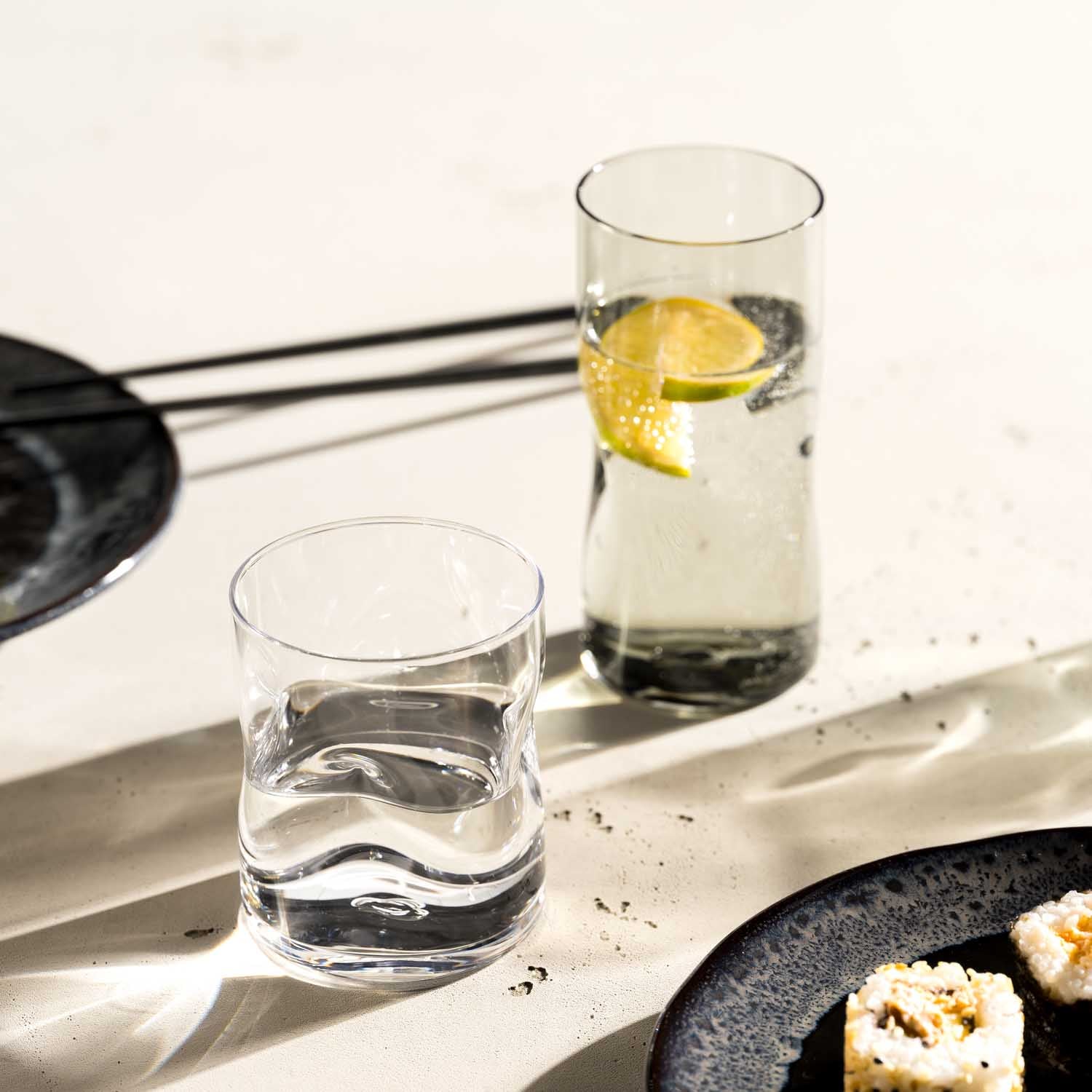 Trinkgläser VESUVIO auf gedecktem Tisch mit Wasser, Zitrone und Speisen