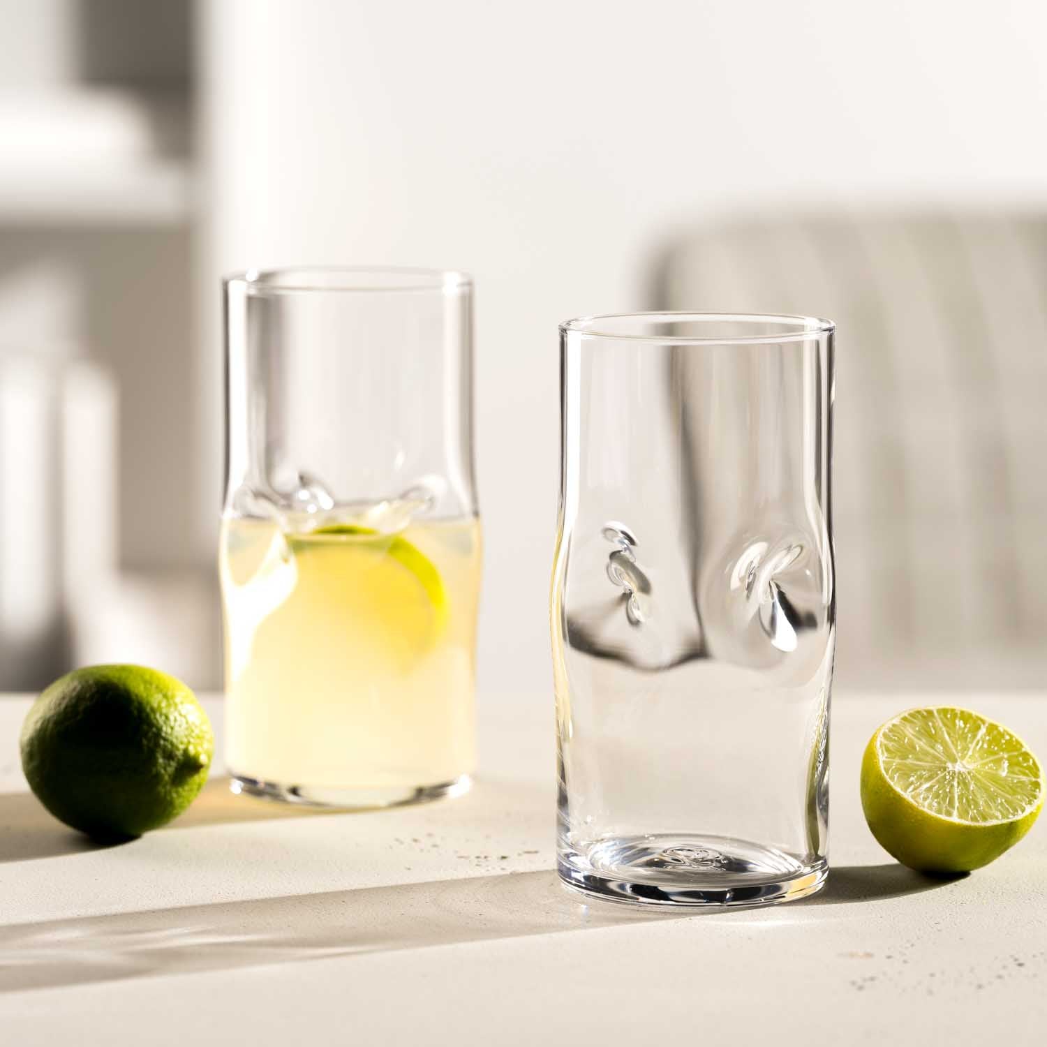 Trinkglas VESUVIO mit Limette und Zitronenwasser auf weißer Oberfläche