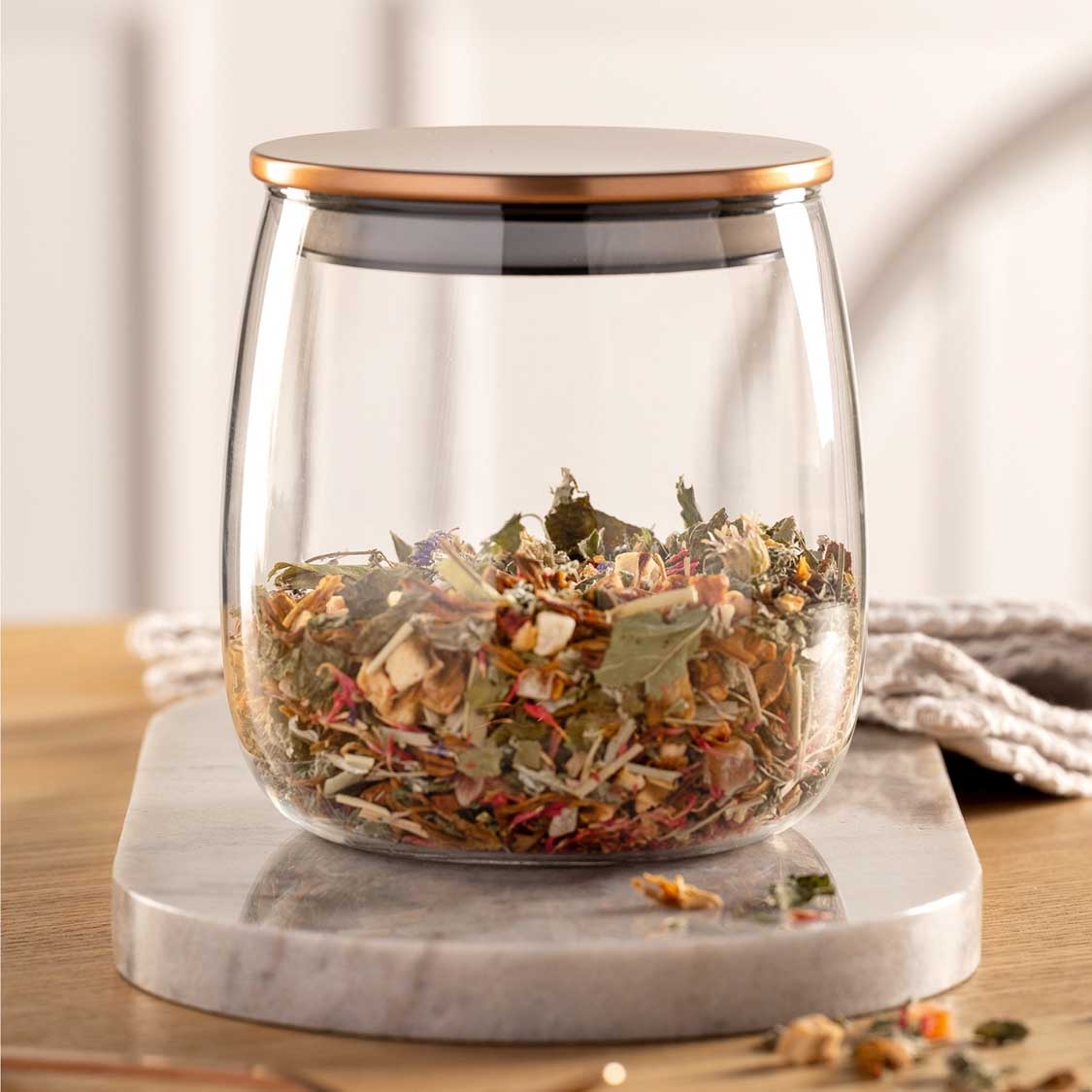 Teedose TÈ PER TE mit Kräutertee auf Marmorsockel, Holztisch