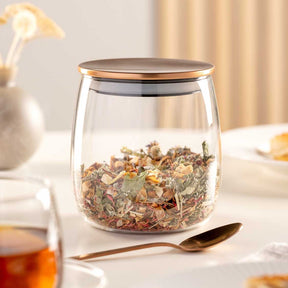 Teedose TÈ PER TE mit Kräutertee gefüllt auf gedecktem Tisch