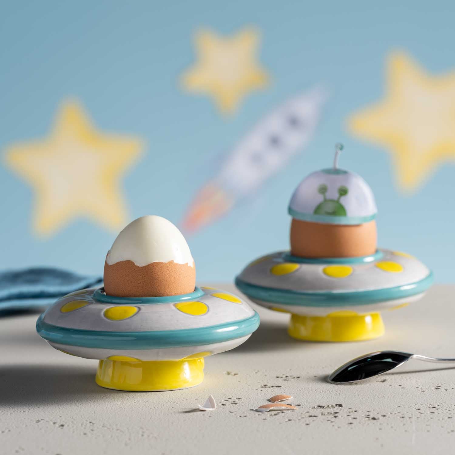 Zwei Eierbecher BAMBINI AVVENTURA Ufo auf Sand mit Sternen und Rakete im Hintergrund