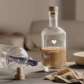 Flasche DIABOLO mit Gravur "Mir Liebe gemacht" auf Wohnzimmertisch, umgeben von Glas und Dekoration
