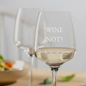 Weißweinglas CESTI mit Gravur "WINE NOT?" auf Esstisch mit Speisen