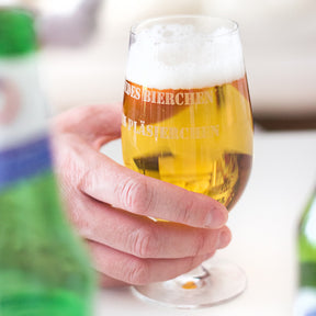 Hand hält Bierglas CIAO+ mit Gravur gefüllt mit Bier