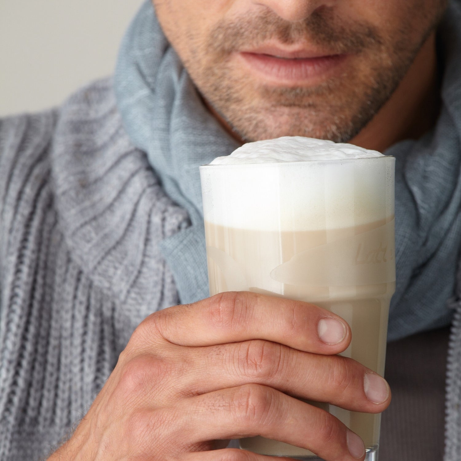 Mann hält Becher SOLO 410 ml mit Cappuccino gefüllt