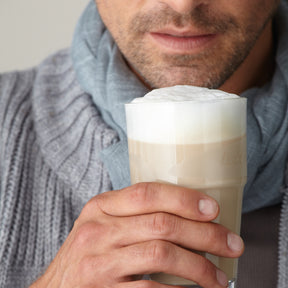 Mann hält Becher SOLO 410 ml mit Cappuccino gefüllt