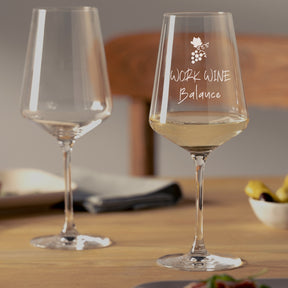 Zwei Weißweingläser PUCCINI auf Holztisch, rechtes Glas mit Gravur "WORK WINE Balance