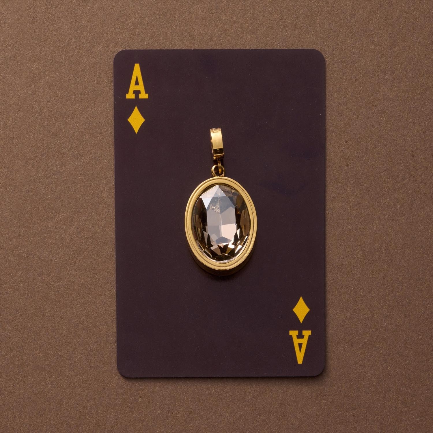 Anhänger TILDE Clip & Mix in Gold auf Spielkarte Pik-Ass vor braunem Hintergrund