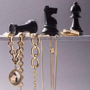 Anhänger TILDE Clip & Mix in Gold an Ketten neben Schachfiguren