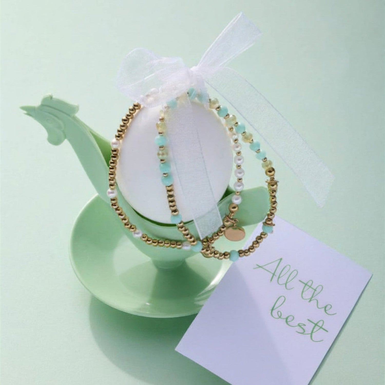 Armband gold EVELYN You & Me mit Perlen auf grünem Glaspokal und Geschenkkarte