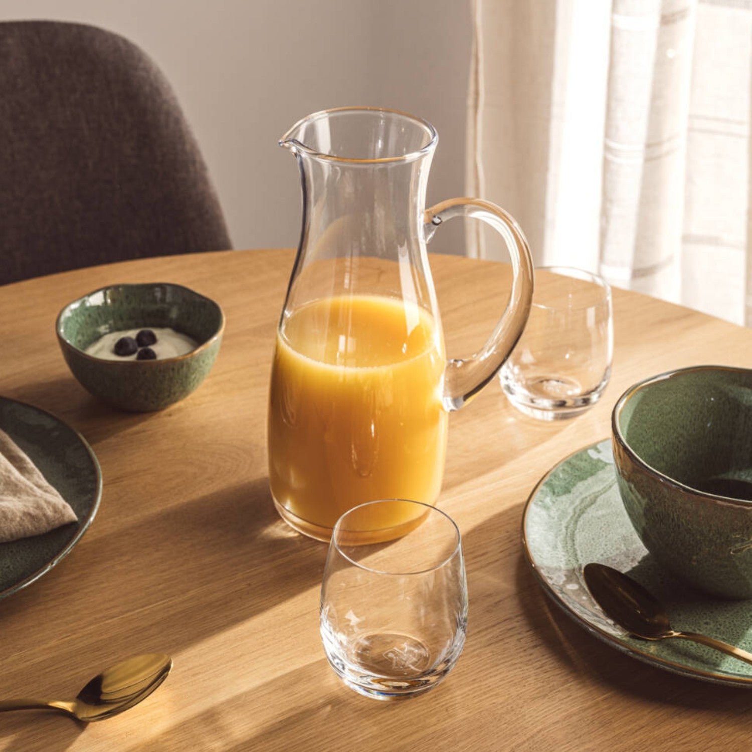 Krug PIENO 1,5 l mit Orangensaft gefüllt auf gedecktem Esstisch