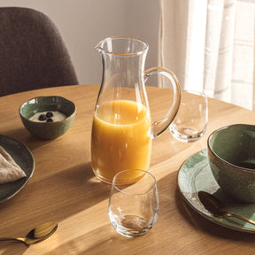Krug PIENO 1,5 l mit Orangensaft gefüllt auf gedecktem Esstisch