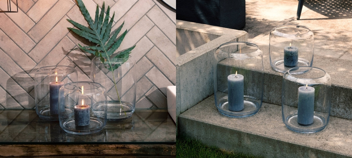 Transparente Glasvasen und Windlichter mit Kerzen sind dekorativ in einem Innenraum und im Außenbereich arrangiert.