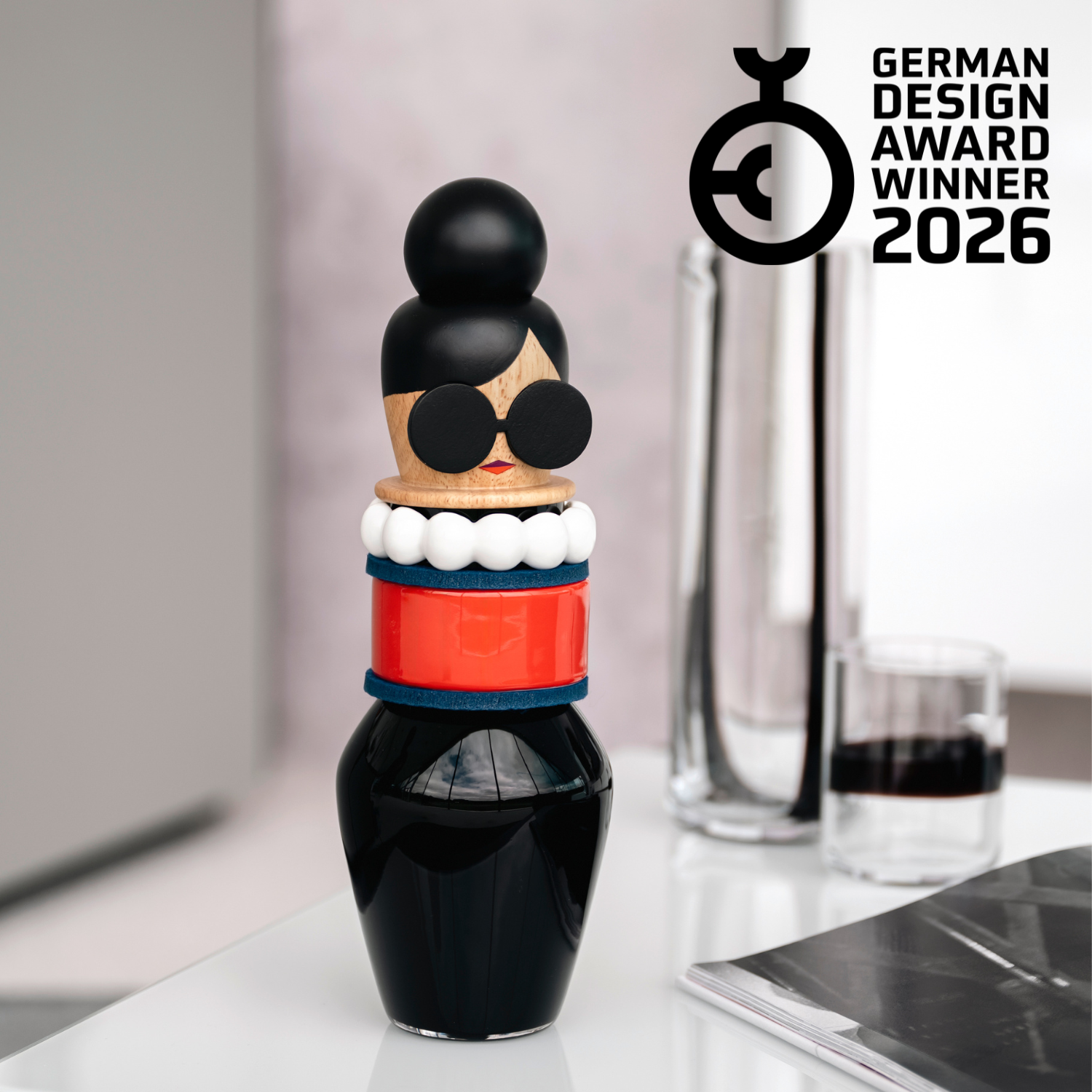 German Design Award Winner 2026 – Bunte Dekofigur mit schwarzem Kopf, Sonnenbrille, roten und blauen Streifen