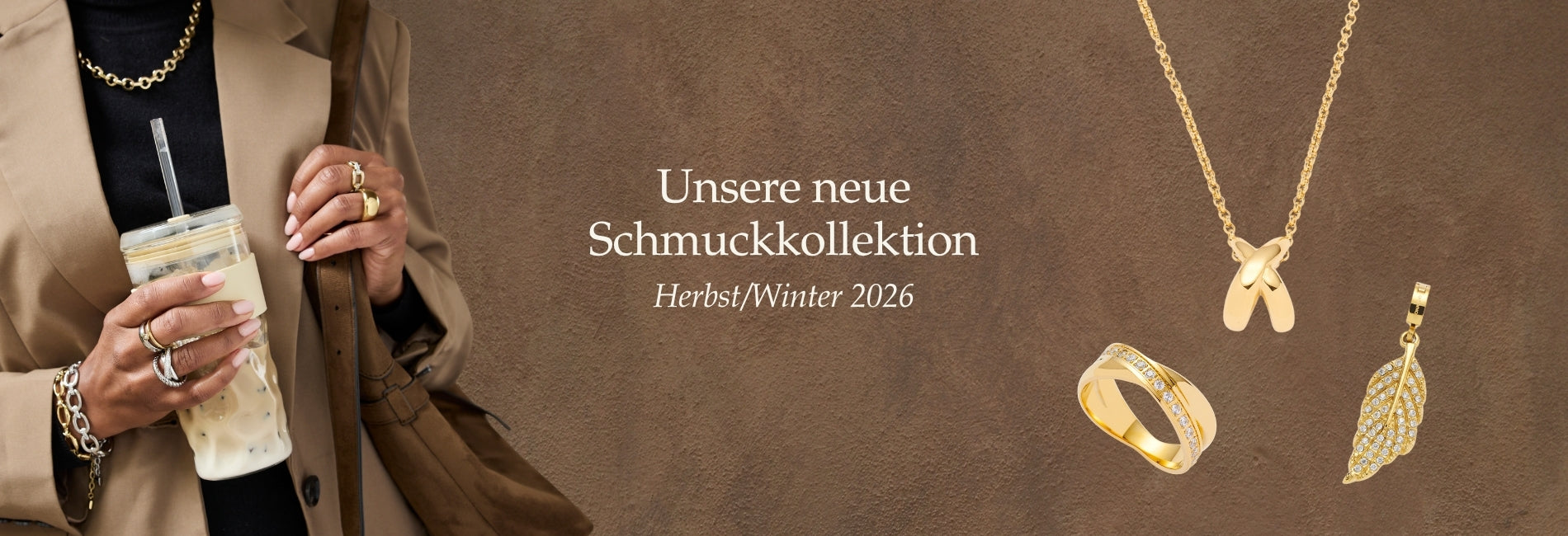 Unsere neue Schmuckkollektion Herbst/Winter 2026. Frau trägt goldene Ringe, Halsketten und Armbänder vor warmem, braunem Hintergrund